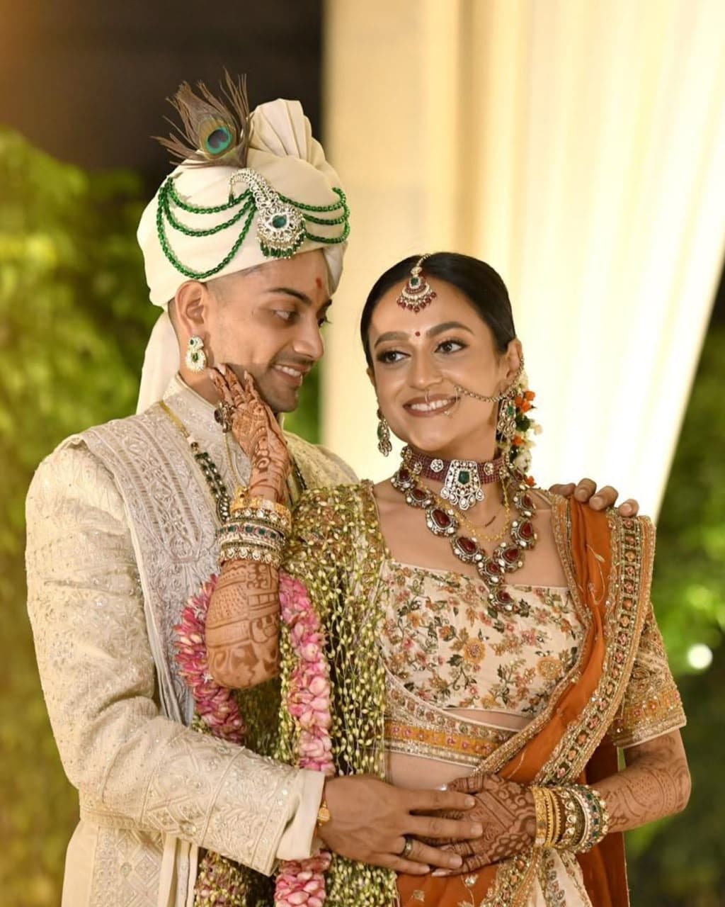 Bride and groom sharing a joyful moment in traditional wedding attire