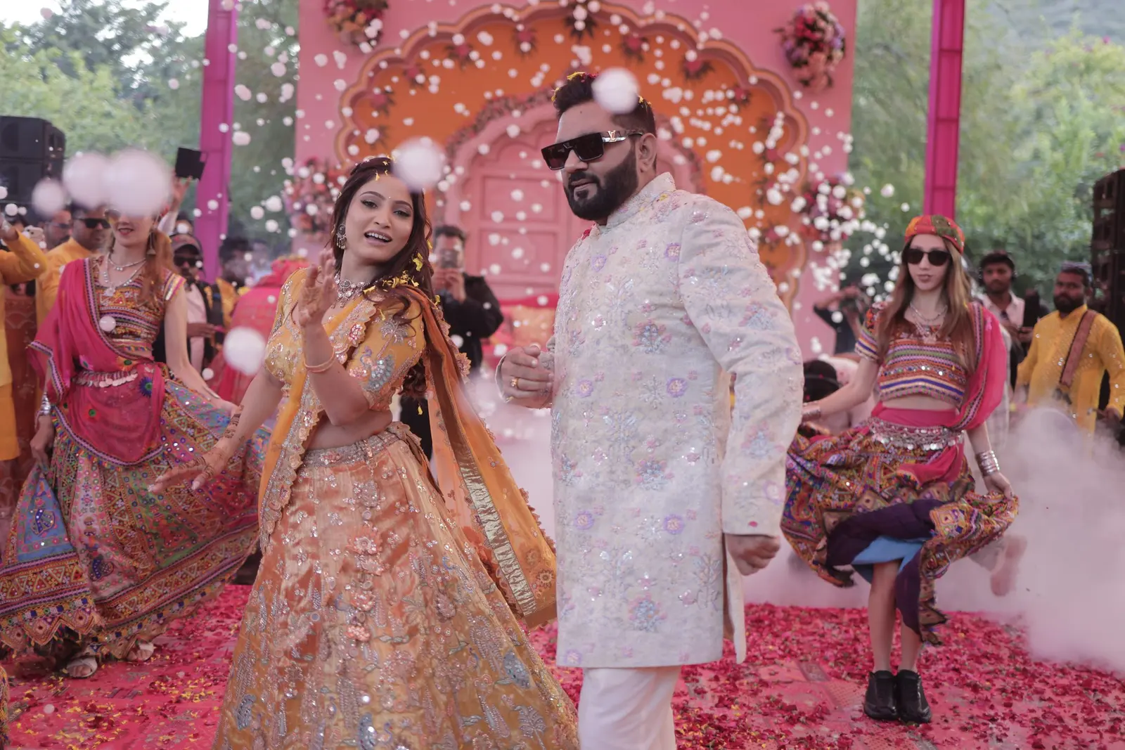 Bride and grooms joyful entry through a shower of petals at their mehndi